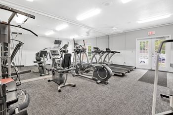 A gym with treadmills, elliptical machines, and other exercise equipment.